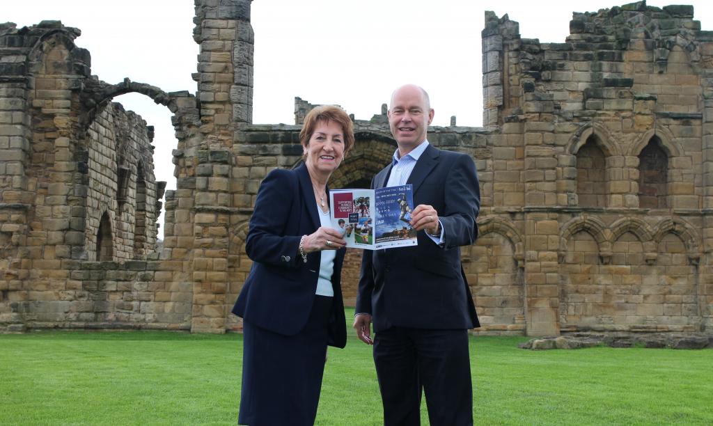 North Tyneside Elected Mayor, Norma Redfearn and Port of Tyne’s Paul Moffat holding a festival programme inside Tynemouth Priory and Castle.