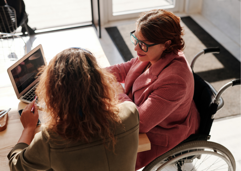 Person in a wheelchair talking with another person over a laptop 