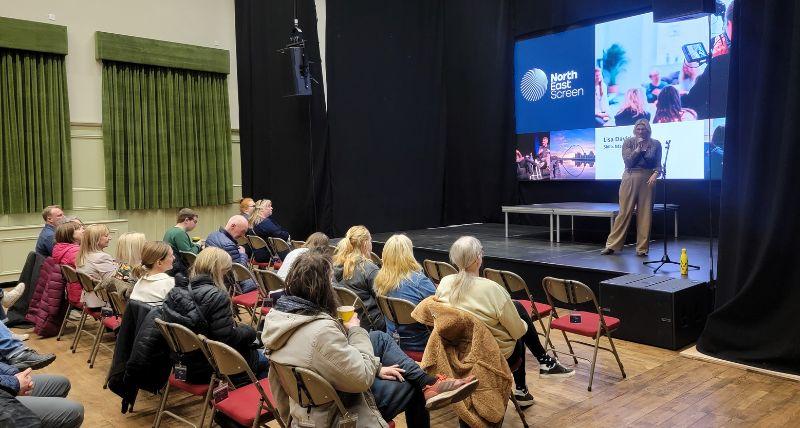 Lisa Davidson from North East Screen on stage at the Exchange with an audience seated in front 